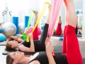 Aerobics pilates women with rubber bands in a row