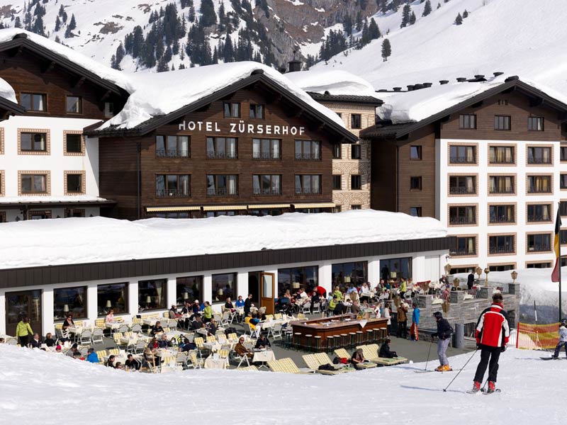aussenansicht_des_hotels_zuerserhof_mit_sonnenterrasse_im_winter_c_sfh_bildkommunikation_hotel_zuerserhof